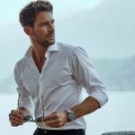 Stylish man in white classic shirt, looking at the mountains view